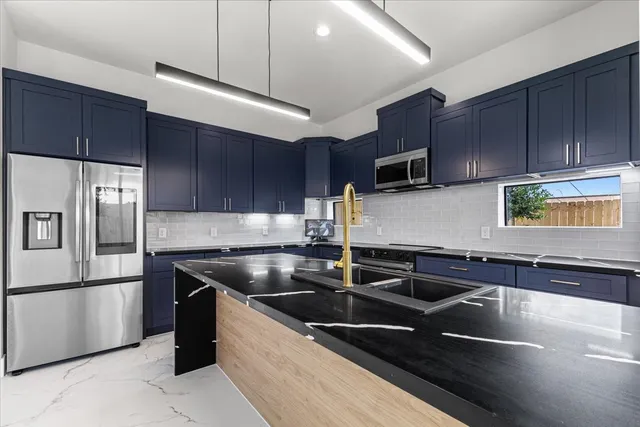 a kitchen with stainless steel appliances granite countertop a sink stove and microwave