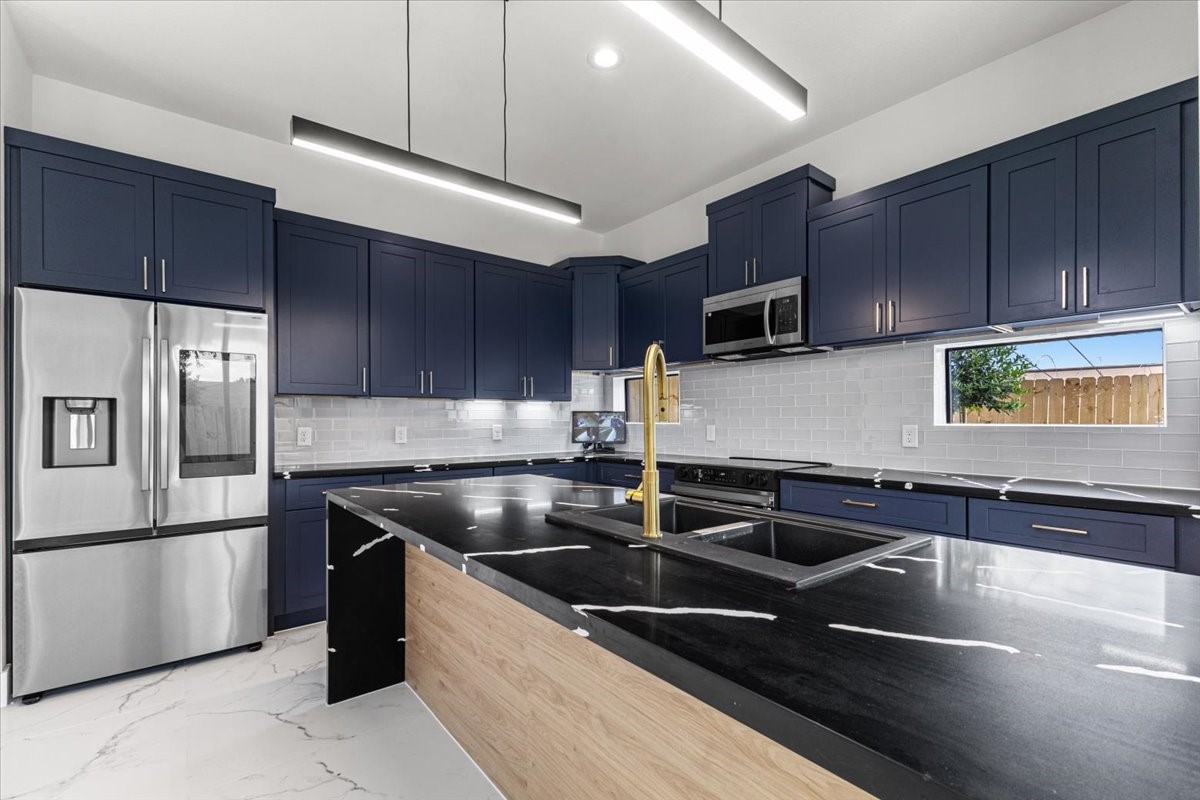 5110 Longmeadow Street, Unit B Houston, TX 77033 - Photo 9 of 25 a kitchen with granite countertop a sink stainless steel appliances and cabinets