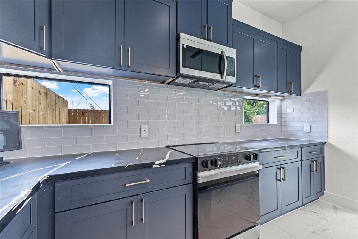5110 Longmeadow Street, Unit B Houston, TX 77033 - Photo 10 of 25 a kitchen with stainless steel appliances granite countertop a sink stove and microwave