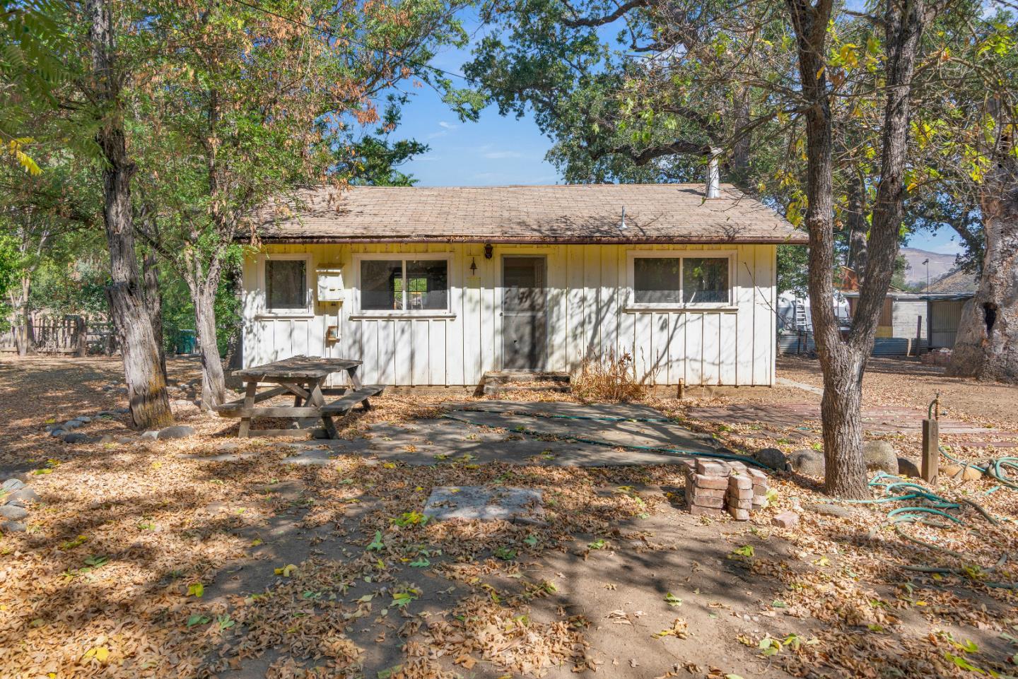 a view of a house with backyard and a tree