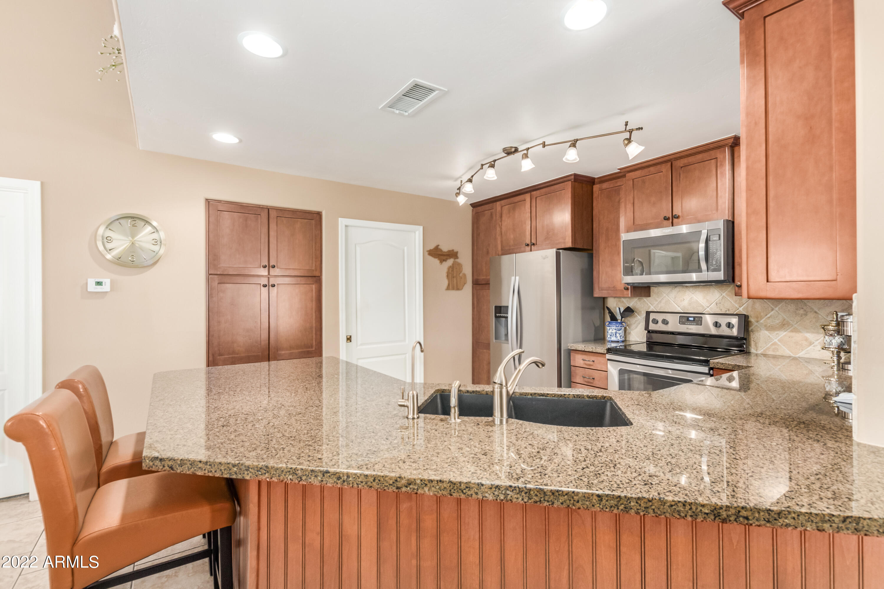 5830 East McKellips Road, Unit 76 Mesa, AZ 85215 - Photo 7 of 33 a kitchen with stainless steel appliances granite countertop a sink refrigerator and microwave