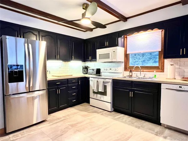a kitchen with stainless steel appliances granite countertop a refrigerator and a sink