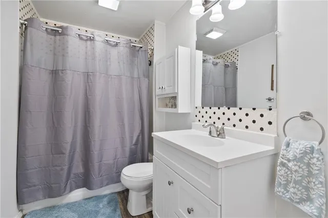 a bathroom with a sink a toilet and shower curtain