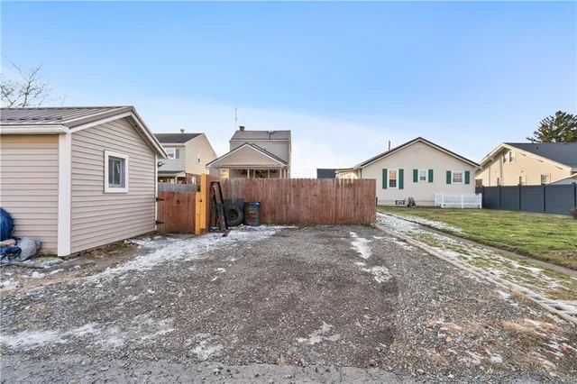 a view of a house with a yard and wooden fence