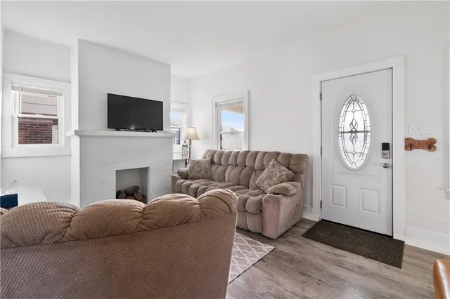 a living room with furniture a flat screen tv and a fireplace