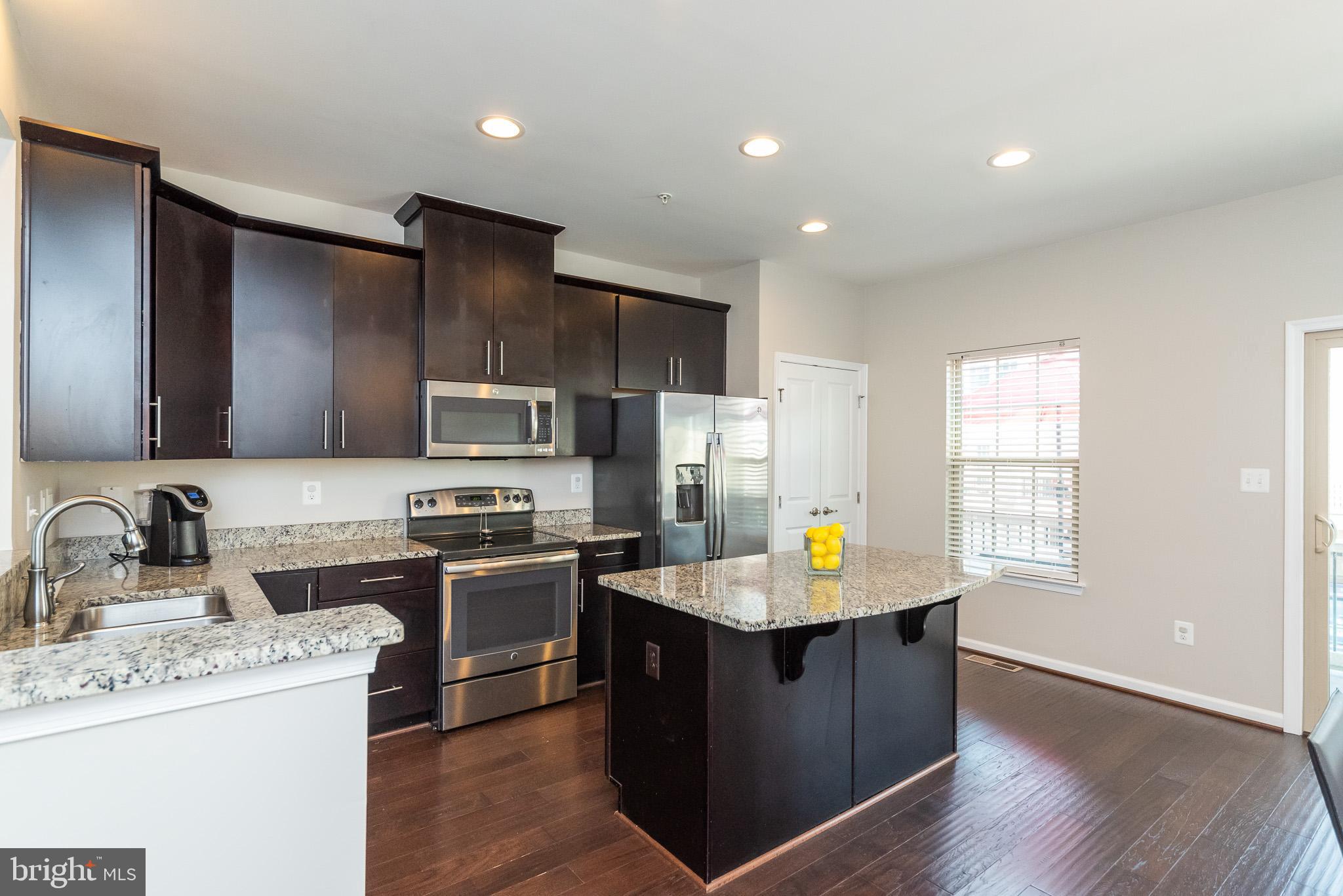 1038 Ramble Run Road Baltimore, MD 21220 - Photo 21 of 47 a kitchen with a stove a sink and a refrigerator
