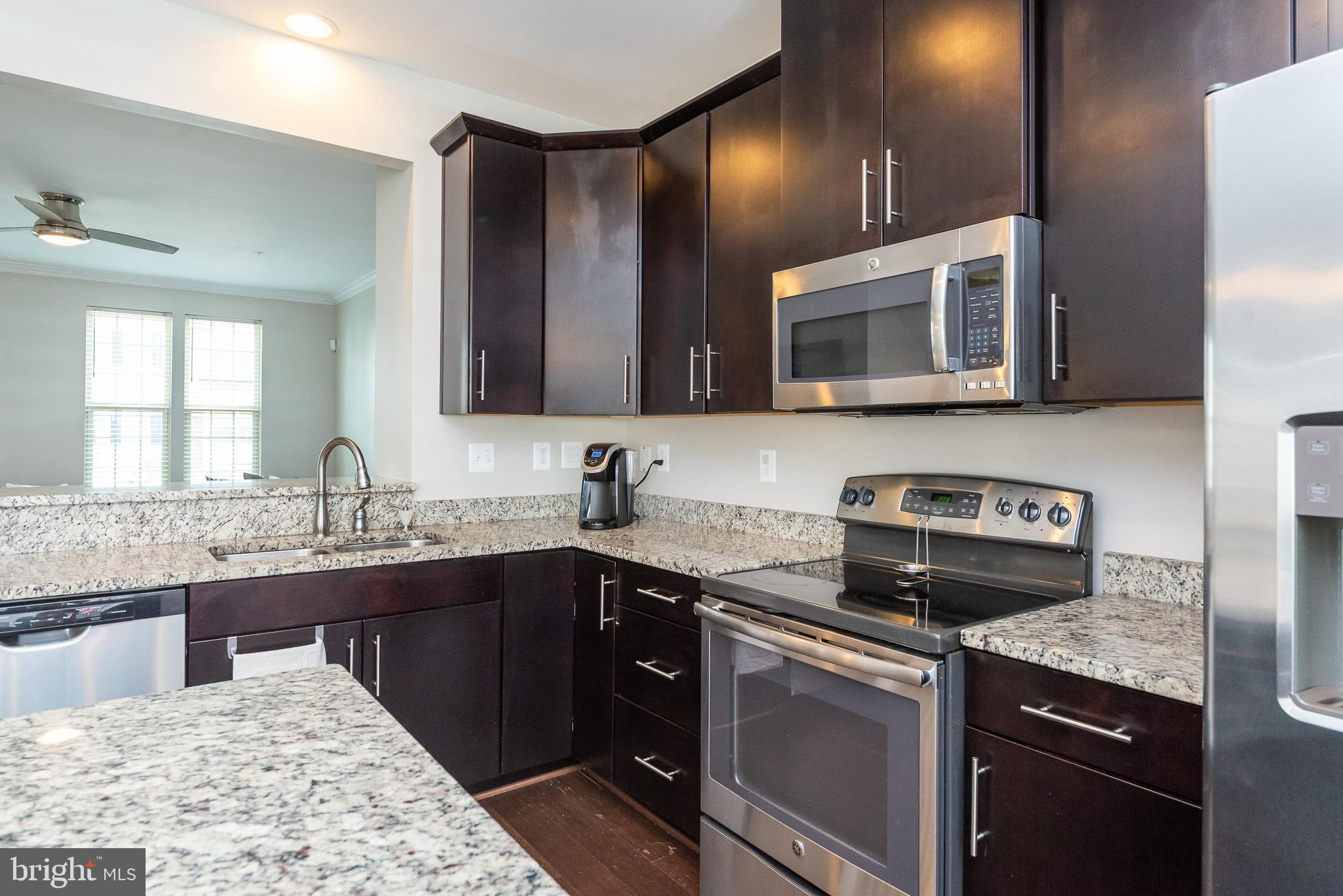 1038 Ramble Run Road Baltimore, MD 21220 - Photo 24 of 47 a kitchen with stainless steel appliances granite countertop a sink stove and microwave