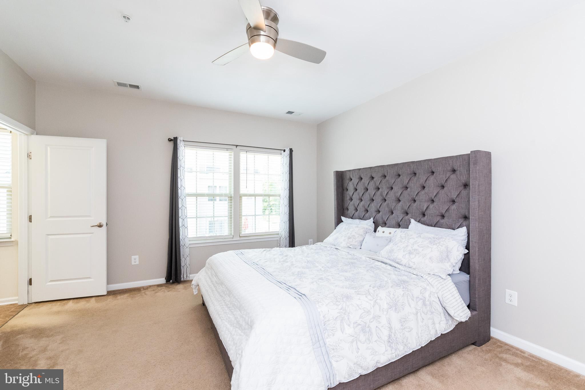 1038 Ramble Run Road Baltimore, MD 21220 - Photo 32 of 47 a large bed sitting in a bedroom next to a window and a chandelier