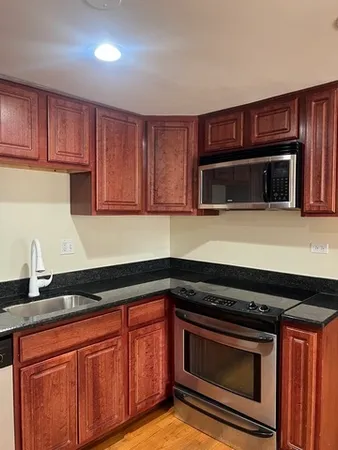 a kitchen with granite countertop a stove microwave and sink