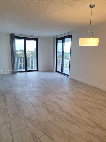 a view of an empty room with glass door and balcony