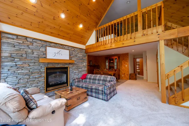 a living room with furniture a fireplace and a ceiling fan