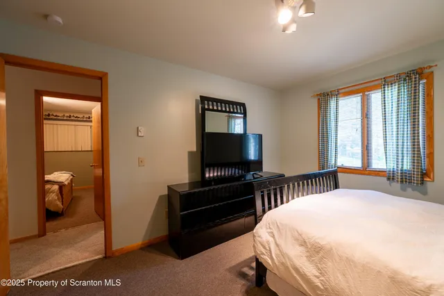 a bedroom with a bed and a television