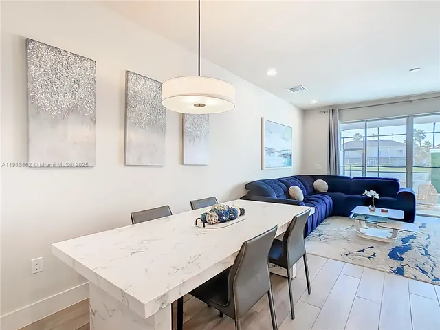 a view of a dining room with furniture and a chandelier