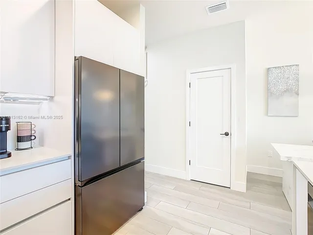 a kitchen with kitchen island a sink stove and refrigerator