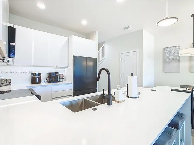 a kitchen with refrigerator and chairs