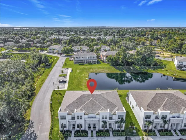 an aerial view of residential houses with outdoor space and ocean view