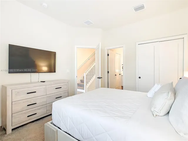 a bedroom with a bed and a flat screen tv