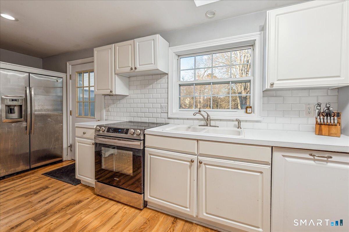 11 Margaret Street Norwalk, CT 06851 - Photo 13 of 26 a kitchen with stainless steel appliances white cabinets and a window