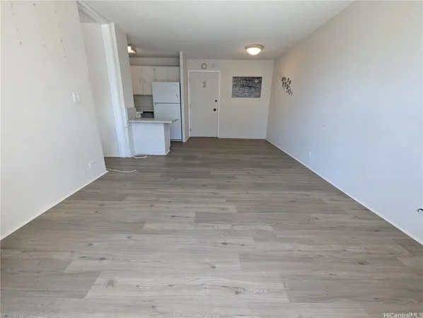 a view of a big room with wooden floor and windows