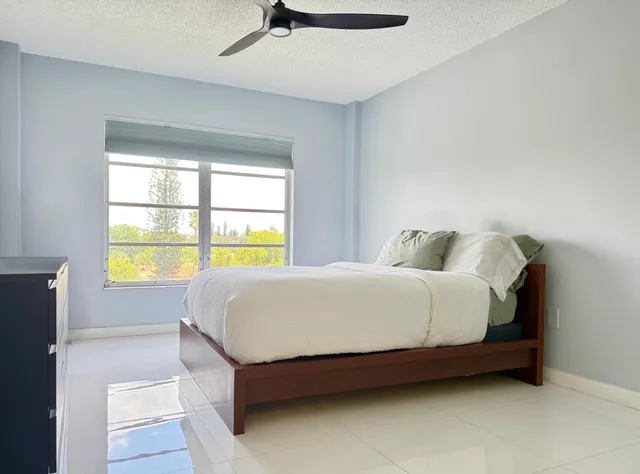 a large bed sitting in a bedroom next to a window