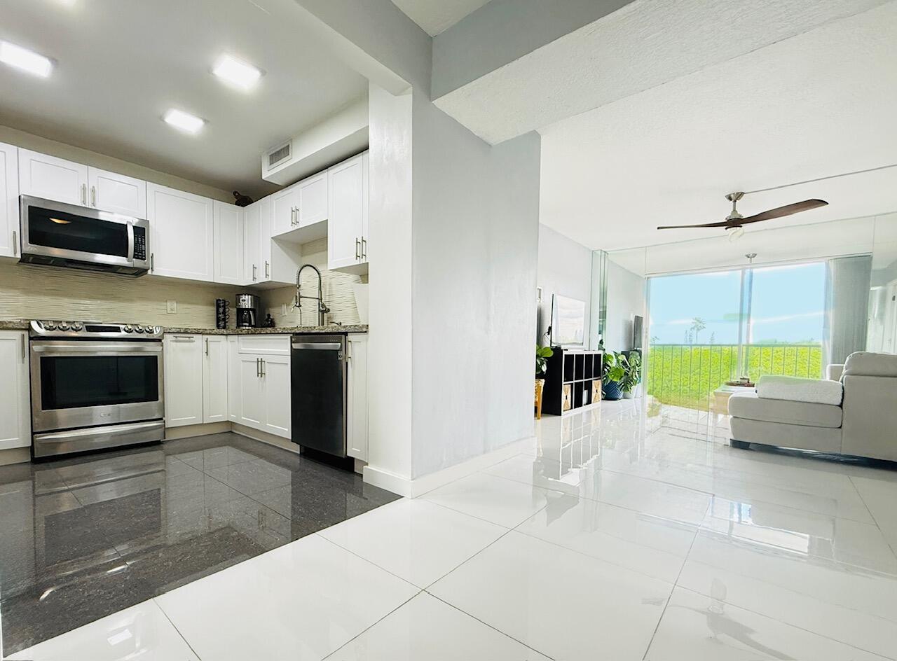 4164 Inverrary Drive, Unit 404 Lauderhill, FL 33319 - Photo 2 of 23 a living room with stainless steel appliances kitchen island granite countertop a stove and a sink