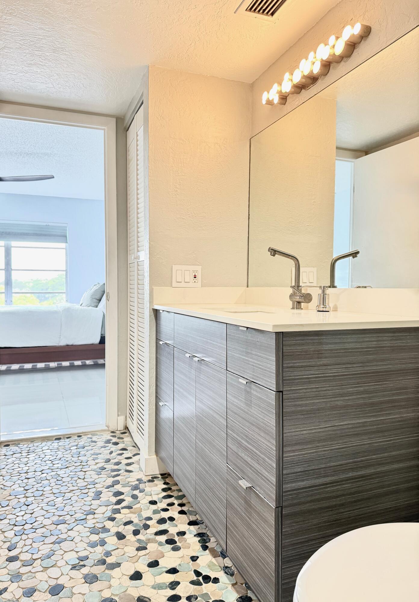 4164 Inverrary Drive, Unit 404 Lauderhill, FL 33319 - Photo 9 of 23 a bathroom with a sink a mirror and a shower