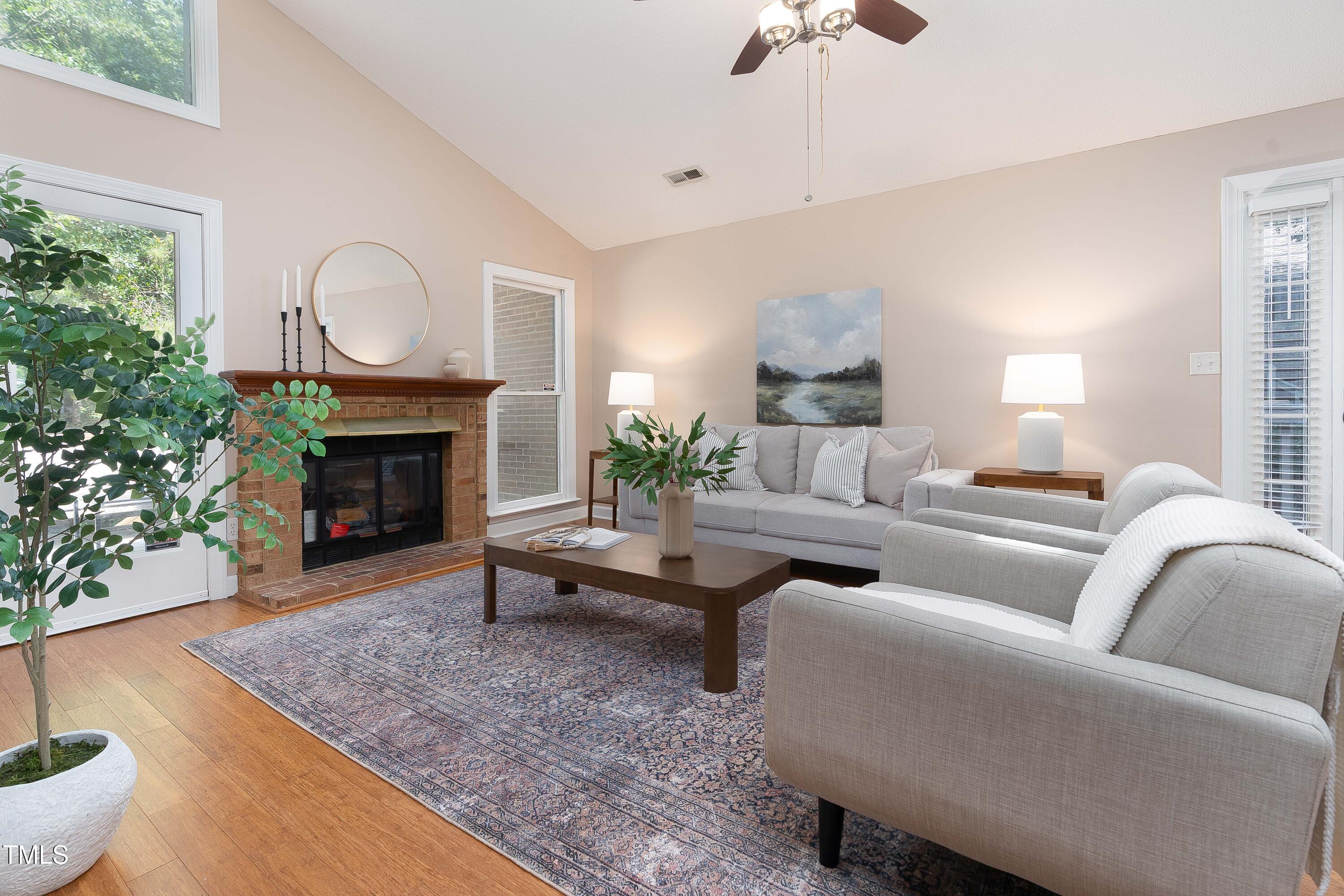 200 West Woodcroft Parkway, Unit 52A Durham, NC 27713 - Photo 4 of 21 a living room with furniture a fireplace and a chandelier