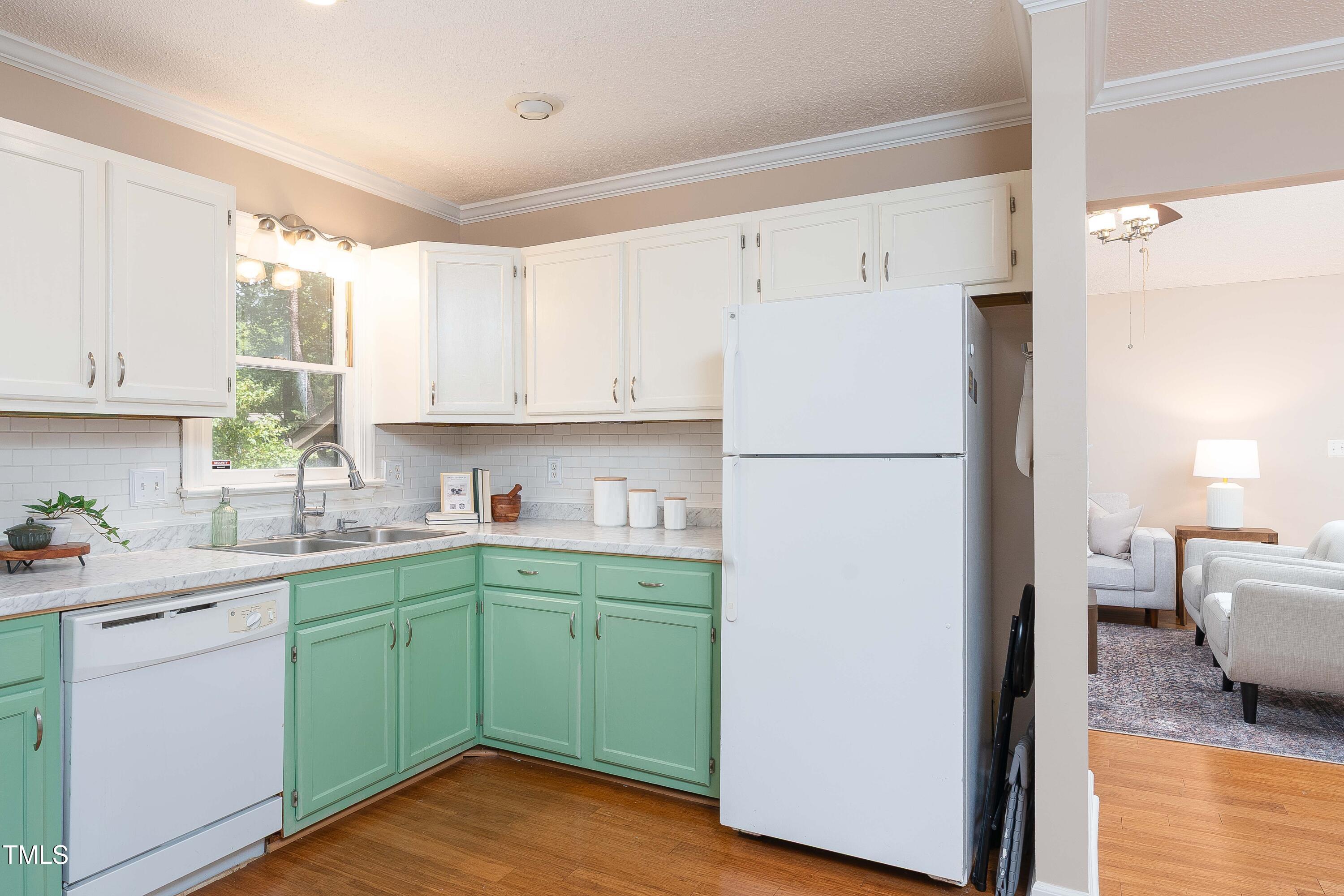 200 West Woodcroft Parkway, Unit 52A Durham, NC 27713 - Photo 10 of 21 a kitchen with a refrigerator a sink and dishwasher with white cabinets