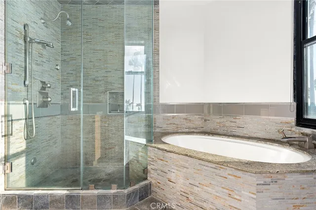 a bathroom with a granite countertop bathtub and a shower
