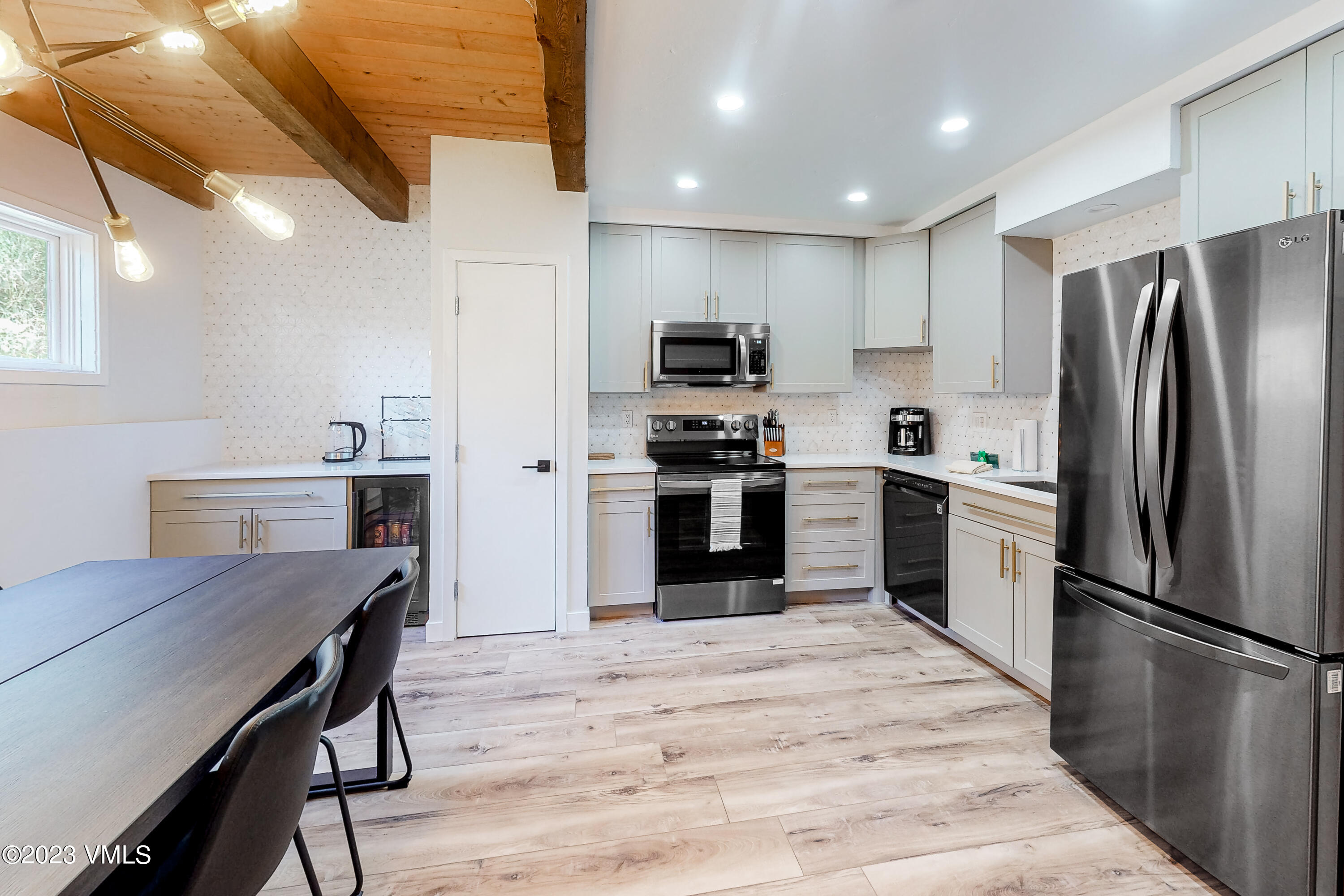 1839 Meadow Ridge Road, Unit D Vail, CO 81657 - Photo 4 of 19 a kitchen with a refrigerator a stove microwave oven a sink dishwasher with a dining table and chairs