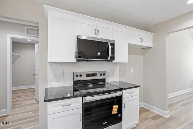 a kitchen with stainless steel appliances granite countertop a stove a microwave and a refrigerator