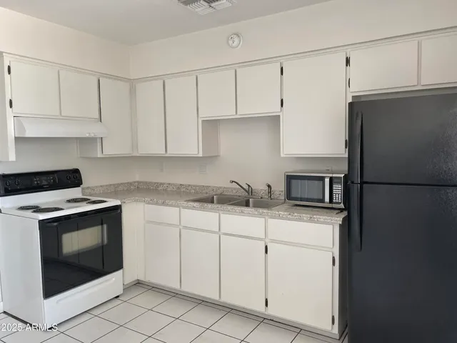 a kitchen with granite countertop white cabinets and white appliances