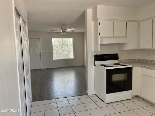 a kitchen with white cabinets and appliances