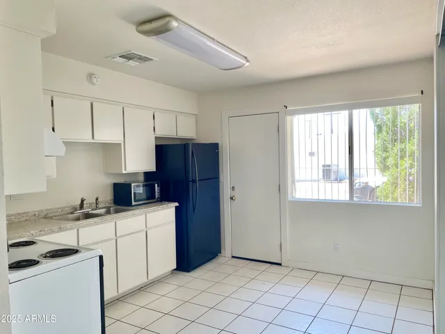 a kitchen with granite countertop a sink window and cabinets