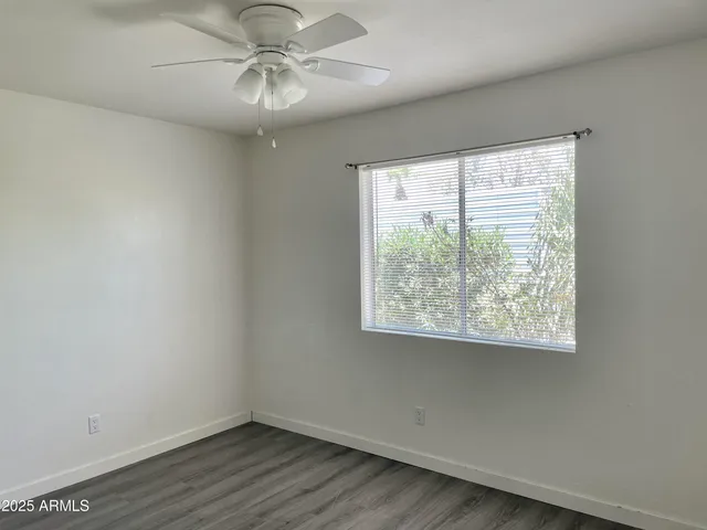 a view of a big room with wooden floor and windows
