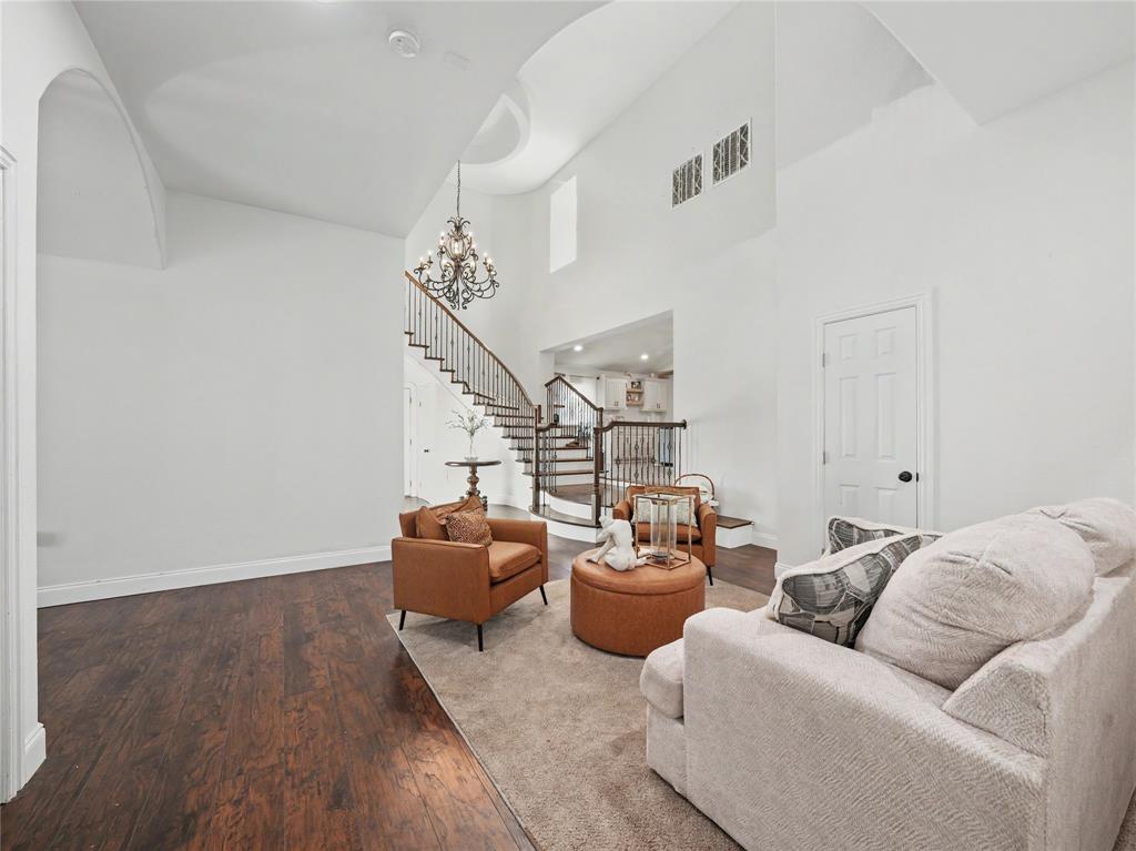 6701 Nauert Road Forest Hill, TX 76140 - Photo 17 of 40 Two-story entry featuring dark wood-finish flooring, a grand staircase with wrought iron balusters, a decorative chandelier, and vaulted ceilings