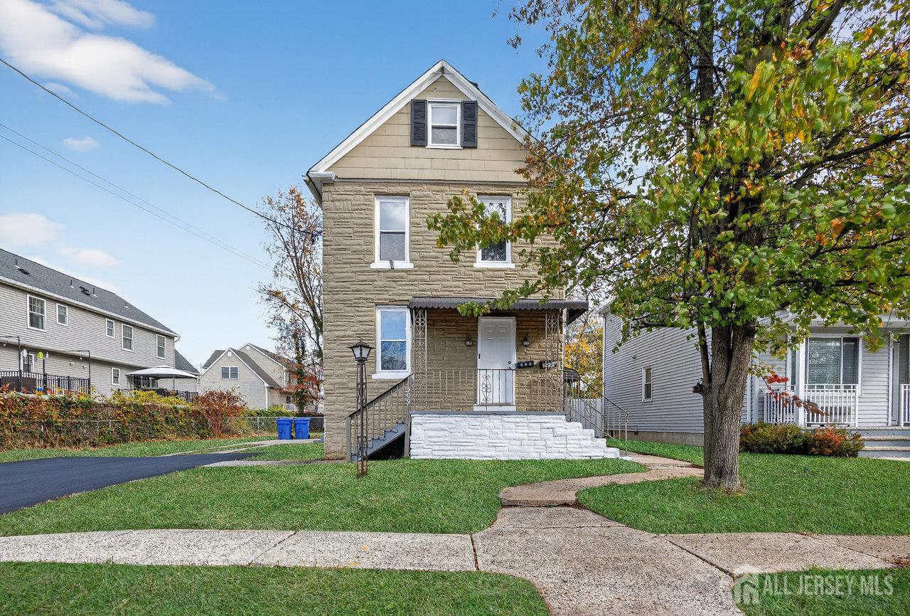 309-311 Pulaski Street Dunellen, NJ 08812 - Photo 1 of 24 a front view of a house with a garden and trees