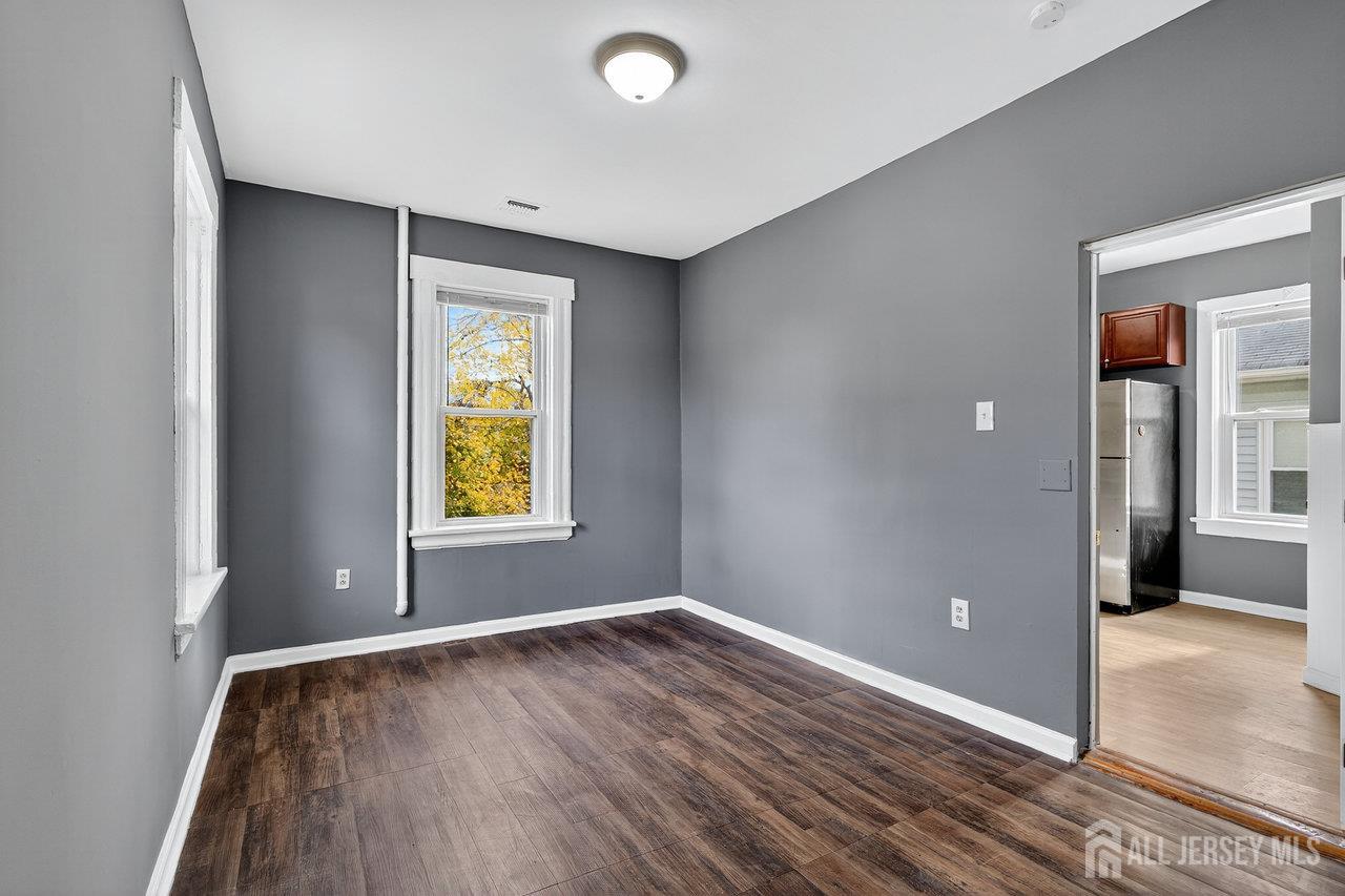 309-311 Pulaski Street Dunellen, NJ 08812 - Photo 11 of 24 wooden floor in an empty room with a window