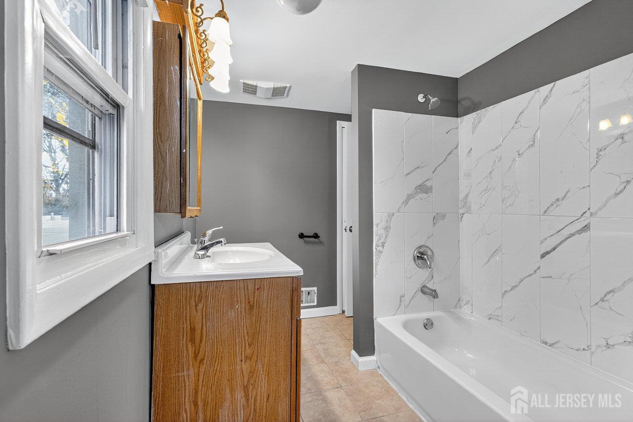 309-311 Pulaski Street Dunellen, NJ 08812 - Photo 15 of 24 a bath room with a sink and a bath tub