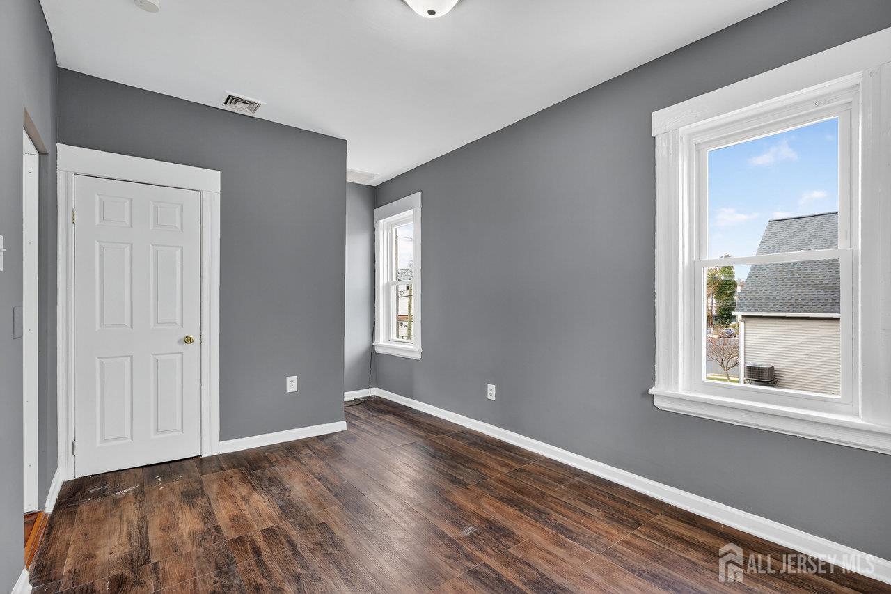 309-311 Pulaski Street Dunellen, NJ 08812 - Photo 16 of 24 a view of empty room with wooden floor and fan