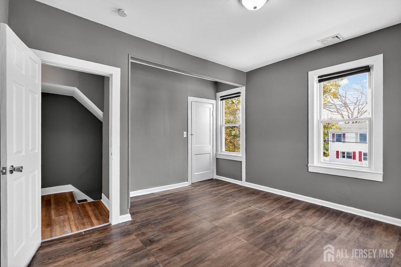 309-311 Pulaski Street Dunellen, NJ 08812 - Photo 18 of 24 an empty room with wooden floor windows and hallway