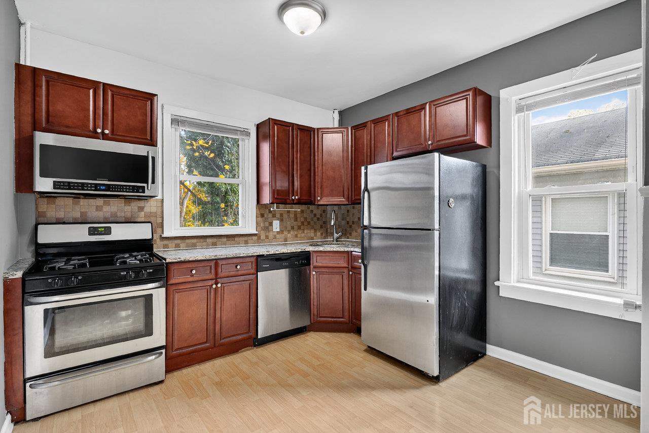 309-311 Pulaski Street Dunellen, NJ 08812 - Photo 8 of 24 a kitchen with stainless steel appliances granite countertop a refrigerator stove and microwave