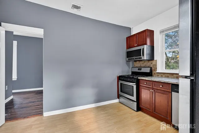a kitchen with stainless steel appliances granite countertop a stove and a refrigerator