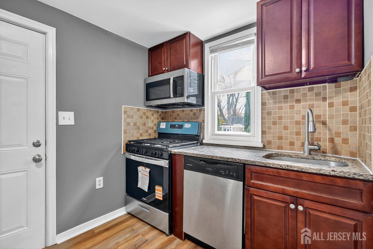 309-311 Pulaski Street Dunellen, NJ 08812 - Photo 10 of 24 a kitchen with stainless steel appliances granite countertop a stove a sink and a microwave