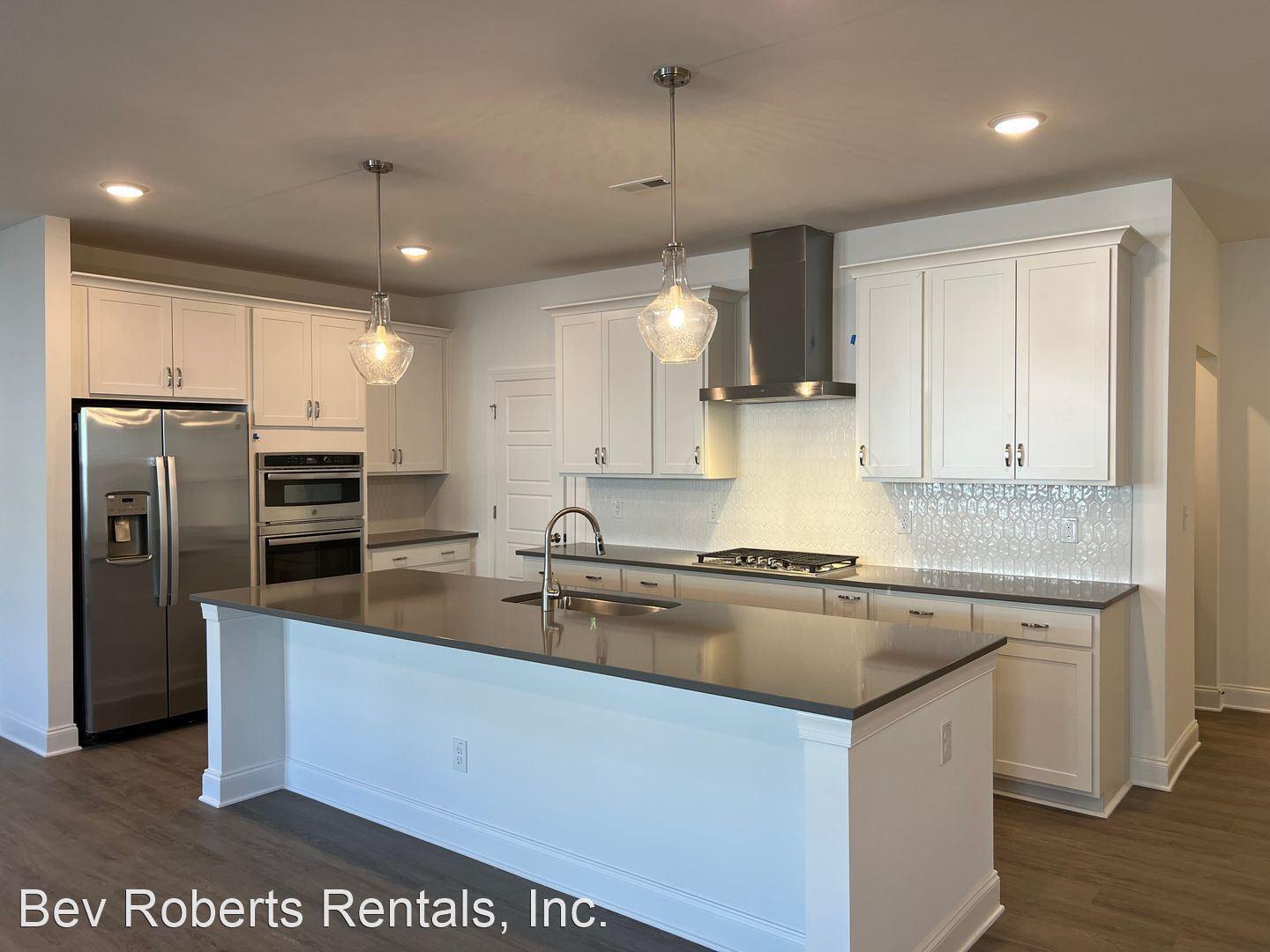 2104 Stegemann Street Apex, NC 27502 - Photo 4 of 29 a kitchen with stainless steel appliances granite countertop a sink a stove and a refrigerator