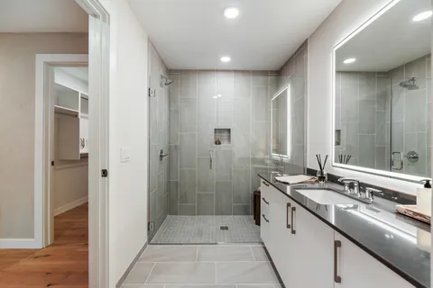a bathroom with a double vanity sink and mirror with shower