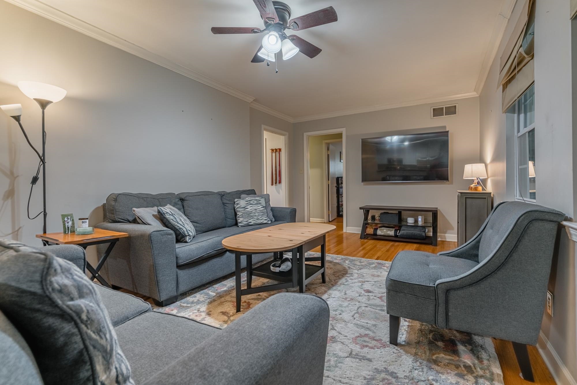 5356 Quince Road Memphis, TN 38119 - Photo 8 of 21 a living room with furniture a fireplace and a flat screen tv