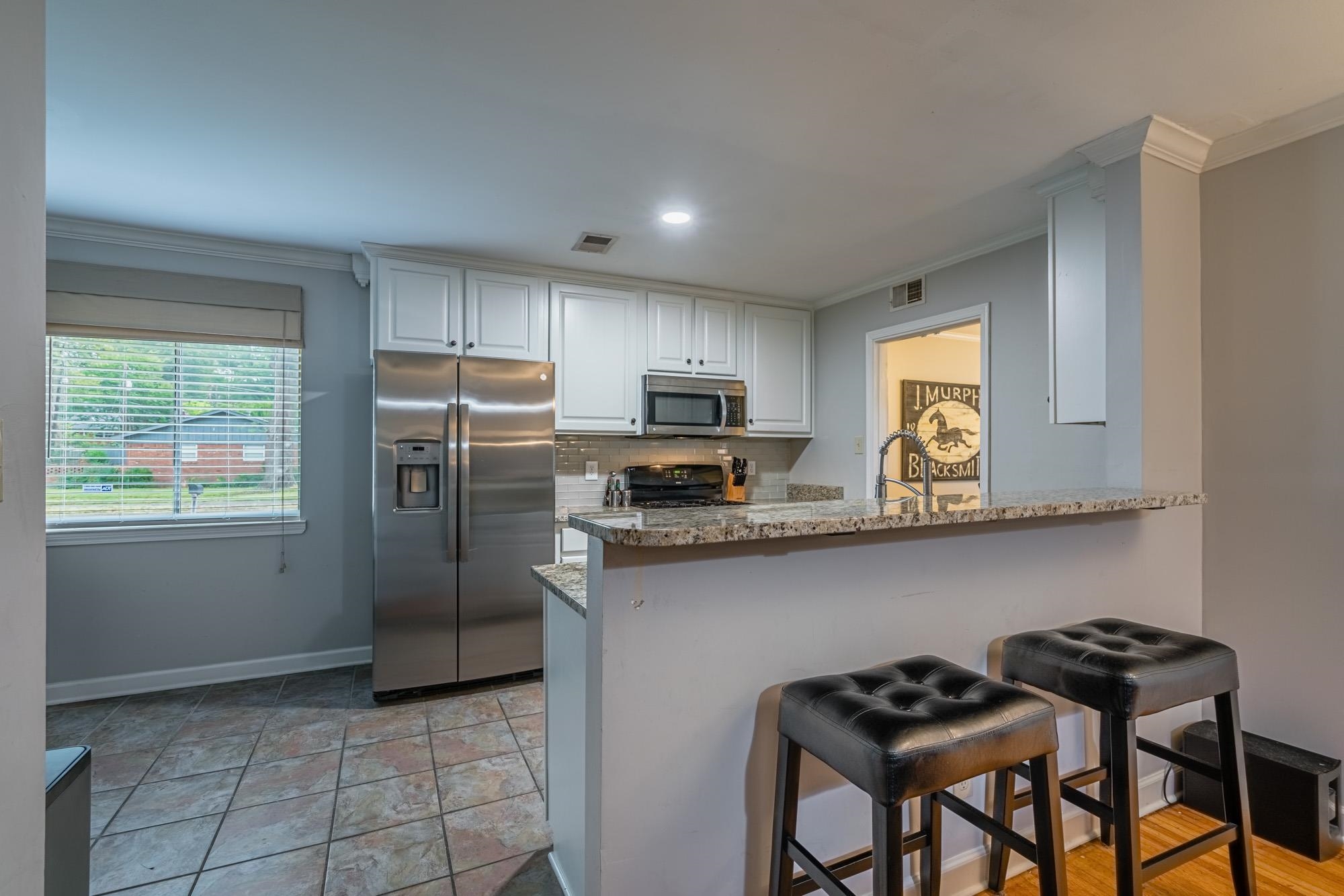 5356 Quince Road Memphis, TN 38119 - Photo 9 of 21 a kitchen with stainless steel appliances granite countertop a refrigerator a stove a sink and a microwave