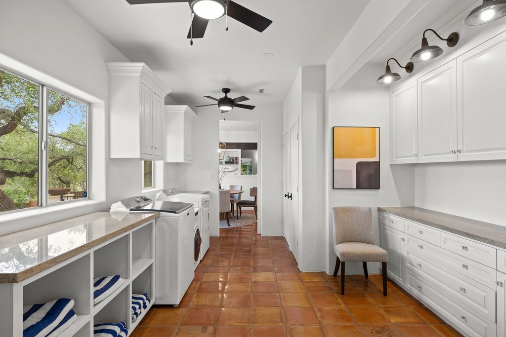 716 North Commons Ford Road Austin, TX 78733 - Photo 19 of 30 Laundry room featuring terra cotta tile flooring and extensive white cabinetry