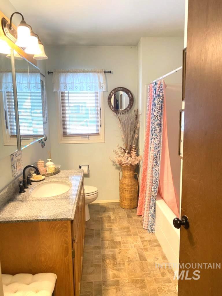 138 Timberline Drive Pierce, ID 83546 - Photo 11 of 28 Bathroom featuring vanity, shower / tub combo with curtain, and stone finish flooring